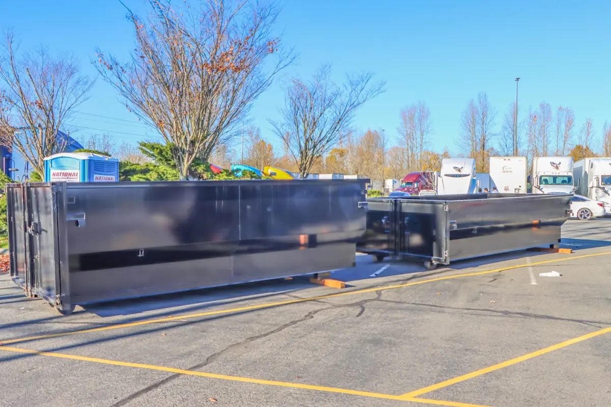 Professional dumpster rental service with roll-off container on residential driveway in Grenada